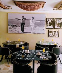 圣玛尔塔Santa Sophia Del Mar B&B hotel的一间用餐室,配有两张桌子和一张墙上的照片
