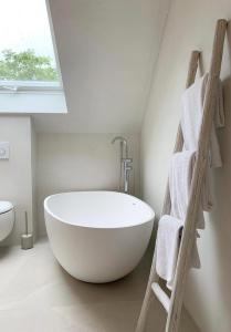 LollarDas Penthouse von Loftalive的带窗户的浴室内的白色浴缸