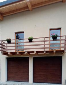 拉特乌伊莱Casa vacanza il Granaio的带阳台和2扇车库门的度假屋