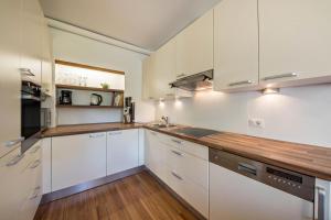 拉古多Ferienwohnung Lafreid Algund的厨房配有白色橱柜和木制台面