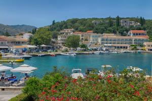 卡西奥皮MANESSIS Apartments Kassiopi Bay Corfu的水中和建筑物中都有船只的港口