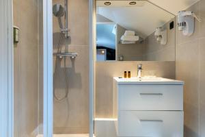 巴黎布雷迪酒店 - 巴黎火车东站的浴室配有白色水槽和淋浴。
