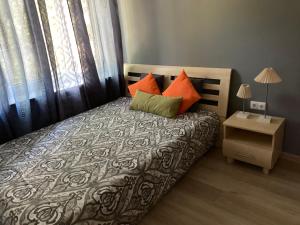 锡拉迈埃VP APARTMENTS的一间卧室配有带橙色和绿色枕头的床