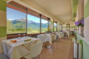 索里科欧洲酒店的餐厅配有桌椅,位于山脉的背景中