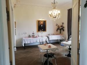 Flavy-le-MartelVILLA HENRI的一间带2张桌子和吊灯的用餐室