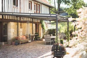 康布勒梅尔Locations - Domaine Le Coq Enchanté的房屋的庭院,配有桌椅