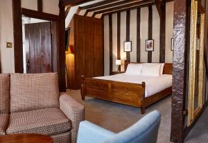 朗梅尔福德Bull Hotel by Greene King Inns的一间卧室配有一张床、一张沙发和一把椅子