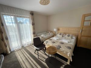 乔尔什滕Pienińska Ostoja的一间卧室配有两张床、一张桌子和一把椅子