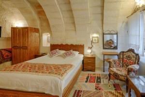 格雷梅郁金香洞穴套房酒店的一间卧室配有一张大床和一把椅子