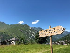 圣马丁德贝尔维尔Les Chalets Du Gypse的山丘上的标志,背景是山丘