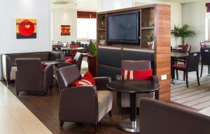 达特福德快捷假日达特福德桥酒店的一间设有椅子和平面电视的等候室