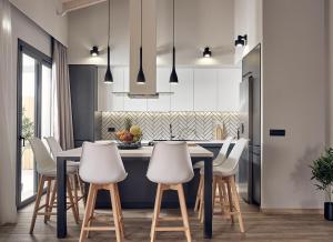 基普塞利Villa Belen的厨房配有黑桌和白色椅子