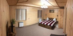 普拉韦Карпатська ніч的卧室配有一张床铺,位于带木墙的房间内