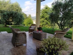 卡普里诺韦罗内塞Carmen de Nella Eco Lodge 4*的庭院配有藤椅和桌子