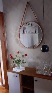 新弗里堡Loft super charmoso no centro de Nova Friburgo的花瓶,桌子上放着鲜花,还有镜子