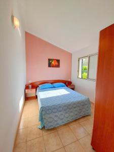 维耶斯泰维拉吉奥马雷卢布公寓式酒店的一间卧室配有一张带蓝色枕头的床