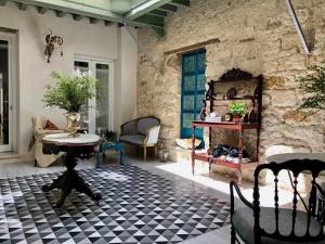 圣玛丽亚港Casa Portus Gaditanus s XVIII Patio Andaluz的客厅配有桌子和石墙