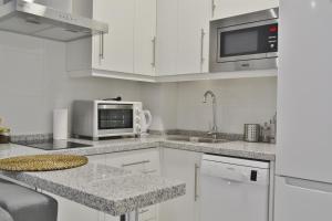 科尔多瓦SunShine Cruz Conde的厨房配有白色橱柜、水槽和微波炉