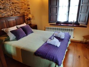 圣埃乌拉利亚德奥斯科斯Casa Viduedo的一间卧室配有一张大床和毛巾