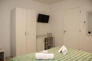 博洛尼亚圣奥索拉城市之家酒店的一间卧室配有带毛巾的床