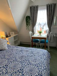 布里德灵顿The George Guest House的卧室配有蓝色和白色的床和一张桌子