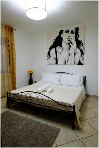 托尔托拉Beb Alla Marina Tortora的一间卧室,配有一张带女性海报的床