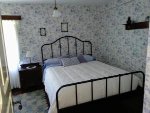 列尔加内斯La Costera en Liérganes, Cabarceno的卧室内的一张床铺,配有蓝色和白色的壁纸