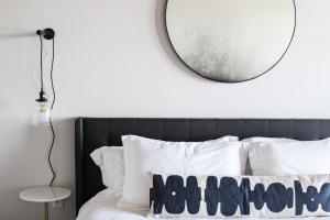 阿斯托里亚Bowline Hotel的卧室配有镜子和白色枕头,位于床上方