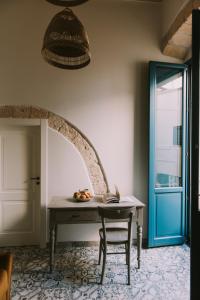阿尔塔穆拉Zia Marietta Guest House的蓝色门的房间里一张桌子和一把椅子