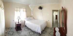 特雷热比奇Rock Side Villa On the Beach的卧室配有白色的床、灯和窗户。