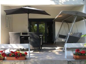 鲍洛通维拉戈什Nefelejcs Apartman的庭院配有遮阳伞、椅子和桌子。