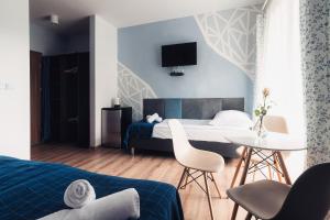 杜什尼基-兹德鲁伊Villa Sudecka的卧室配有一张床和一张桌子及椅子