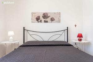 玛丽娜迪曼卡维萨Appartamento Violetta的一间卧室配有一张床和两张带台灯的桌子。