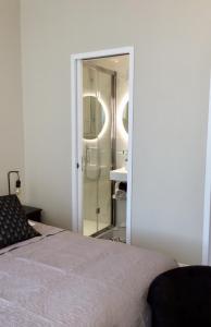 Saint-Laurent-de-Brévedent苏布瓦旅馆的一间卧室配有一张床,浴室设有淋浴。