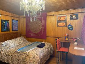 库斯科Casa de la Gringa Mountain House的一间卧室配有一张床、一张桌子和一个吊灯。