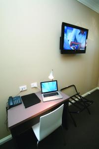 怀阿拉桑丹莫特酒店的一张带笔记本电脑的桌子和一台墙上的电视