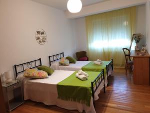 圣地亚哥－德孔波斯特拉Rúa dos Concheiros, 7 Apartamento的一间卧室配有两张带毛巾的床
