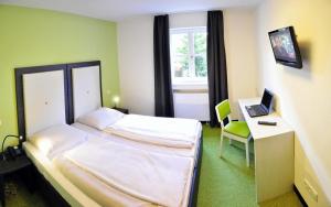 慕尼黑阿米加酒店的一间卧室配有一张床和一张带笔记本电脑的书桌