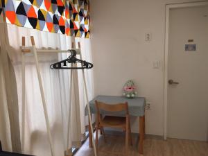 釜山釜山因塞德旅舍的窗帘间里的一张桌子和一把椅子
