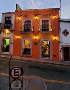 萨卡特卡斯Hotel Villarreal的一座橙色的建筑,前面有标志
