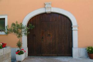 MonrupinoResidence Villa Maria的一座建筑的木门,有两棵盆栽植物