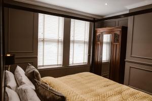 基尔肯尼Kilmore Guesthouse的一间卧室设有一张床和两个窗户。