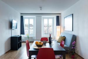 卢塞恩教堂桥公寓的客厅配有桌子和红色椅子