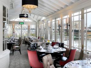 马洛麦克唐纳泰晤垂纶酒店的用餐室设有桌椅和窗户。