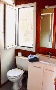 博尼法乔拉哈古伊娜露营地的一间带卫生间和水槽的浴室以及两个窗户。