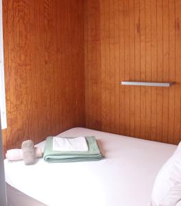 博尼法乔拉哈古伊娜露营地的一张带毛巾和木门的床