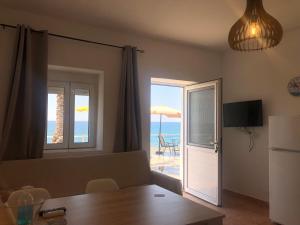 米尔托斯Myrtos Harmony Apartments的客厅配有桌子,享有海景