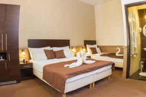 布达佩斯Central Hotel 21 and Apartments的酒店客房,配有两张带毛巾的床