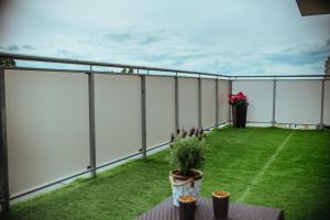 比亚韦斯托克Oaza w Centrum的阳台设有白色的围栏和绿色的庭院。