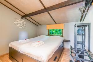科克赛德Cottage 213 in Sunparks Oostduinkerke with free parking and garden的一间卧室配有一张带白色床单的床和一扇窗户。